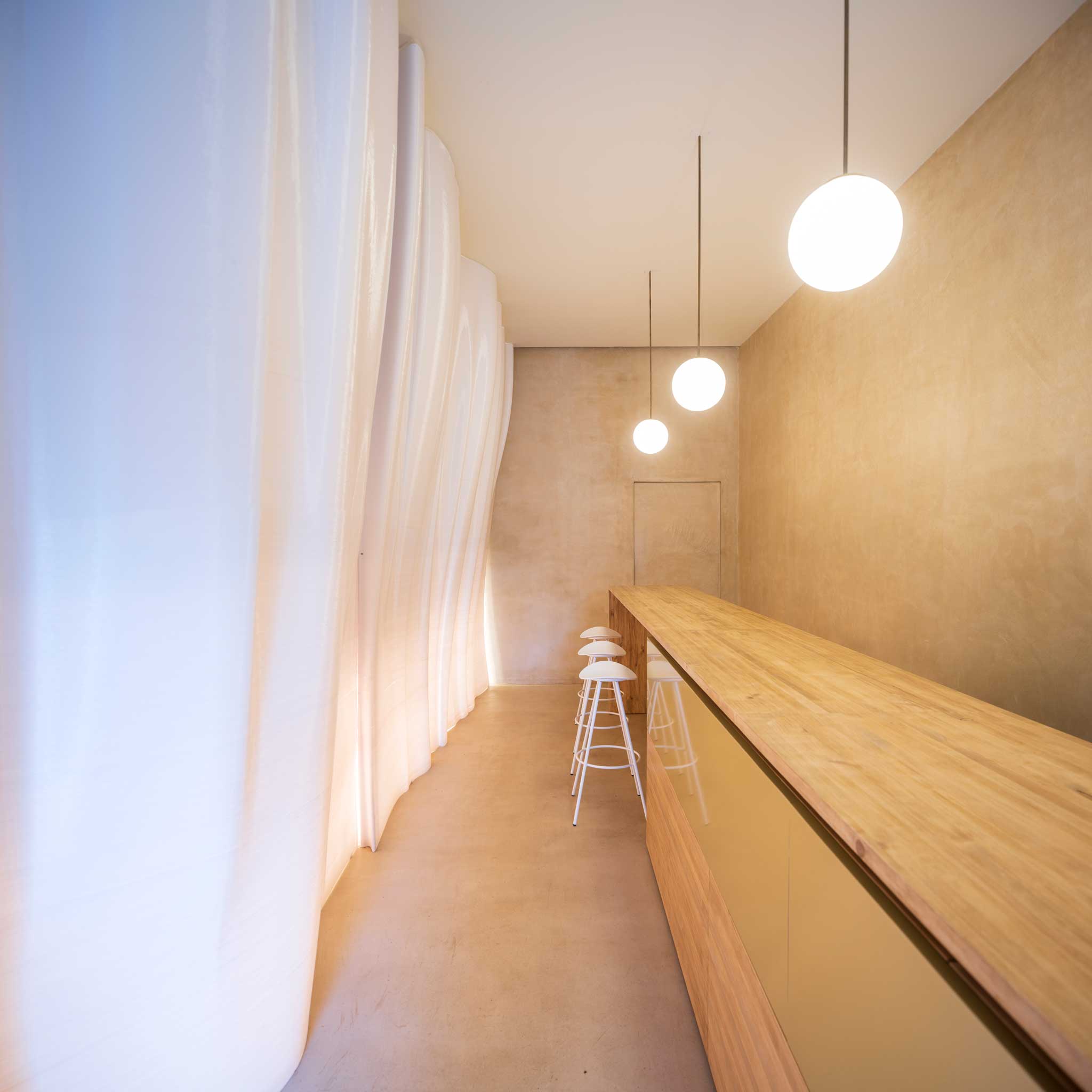 Espacio longitudinal del local con geometrías curvas diseñadas por Nagami y fabricadas con impresión 3D de gran formato.